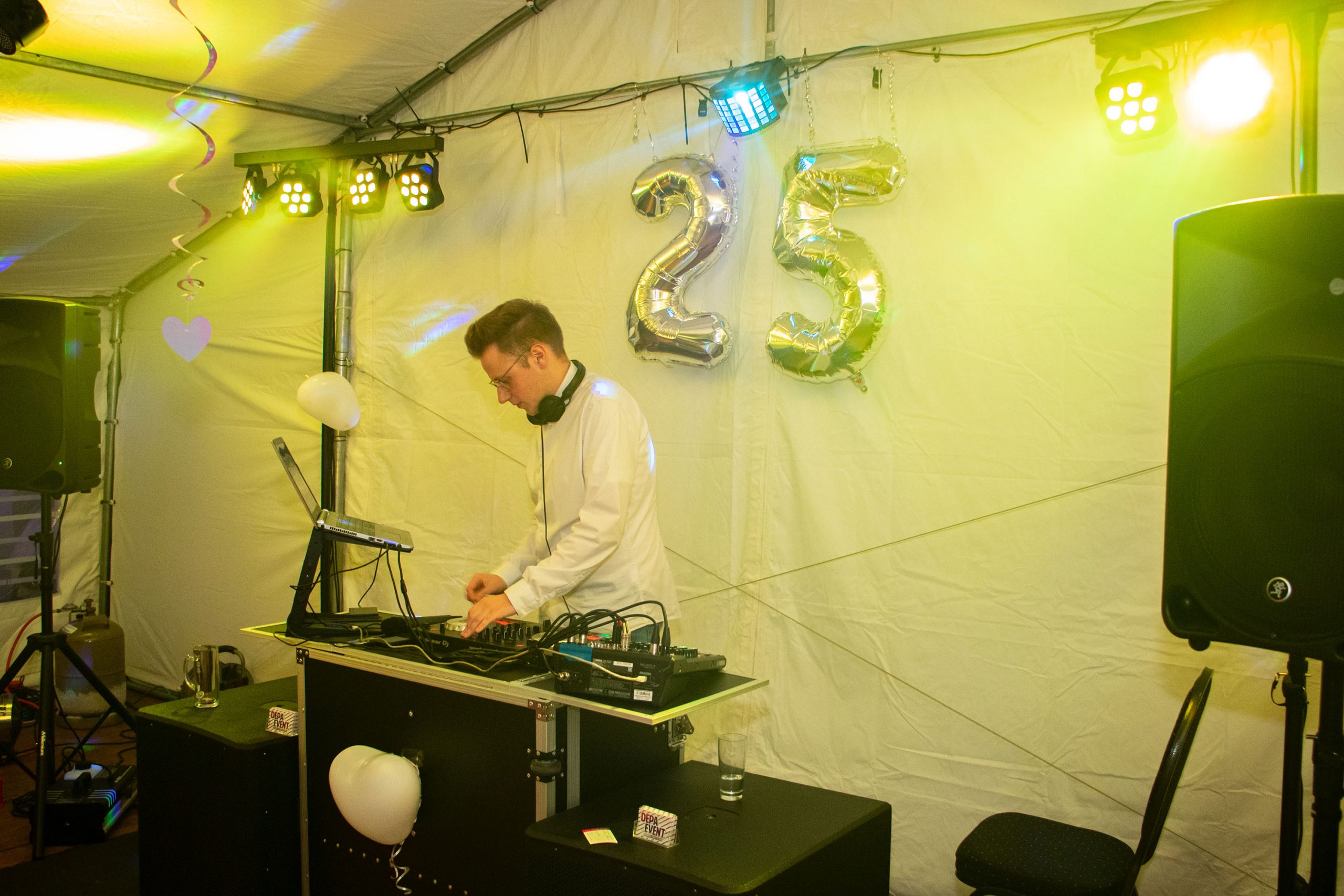 DJ-Setup mit grüner Lichtstimmung auf einer Veranstaltung